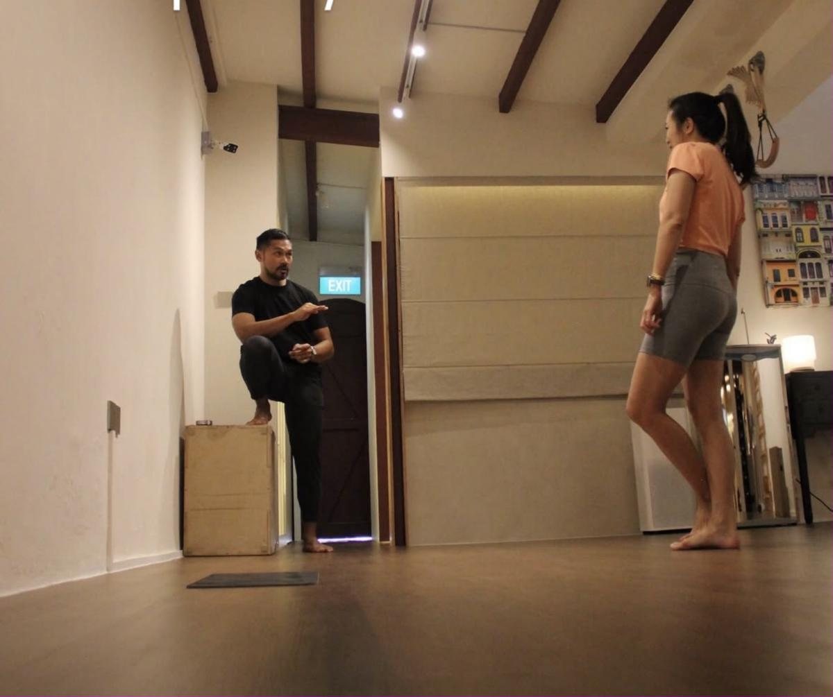 Coach demonstrating single leg balance in the studio